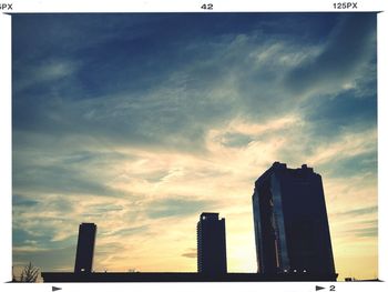 Low angle view of modern buildings against cloudy sky