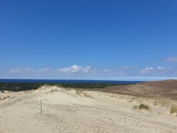 Scenic view of beach against blue sky