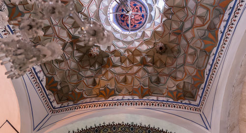 Low angle view of chandelier hanging on ceiling in building