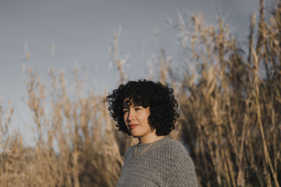 Portrait of woman standing against plants