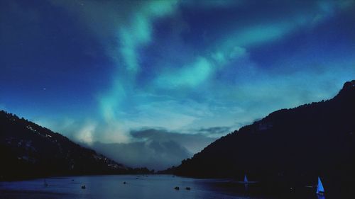 Scenic view of silhouette mountains against dramatic sky