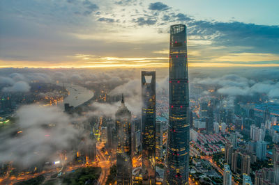 High angle view of modern buildings against sky during sunset