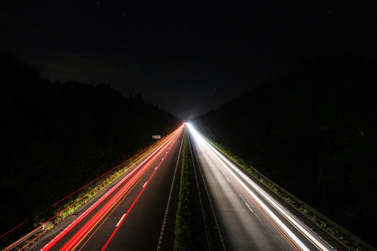 night, motion, light trail, illuminated, road, long exposure, speed, transportation, direction, highway, blurred motion, the way forward, no people, diminishing perspective, high angle view, vanishing point, nature, headlight, sky, traffic, outdoors, multiple lane highway