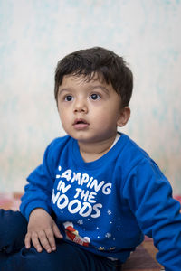 Cute boy looking away while sitting at home