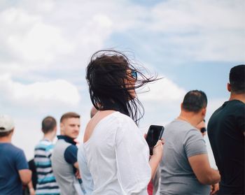 Rear view of people standing against sky