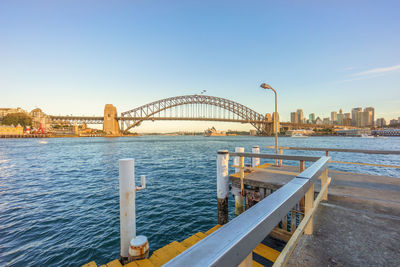Sydney harbour bridge against blue sky seen from pier