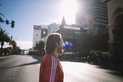 Woman standing on road in city against sky