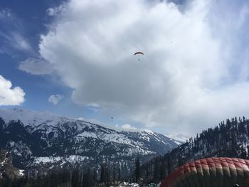 Scenic view of snowcapped mountains against sky and paragliding 