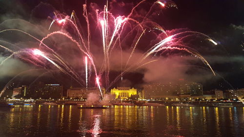 Firework display over river at night