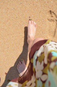 Low section of woman on sand