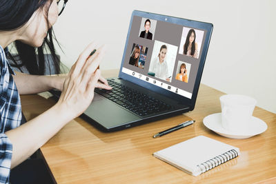 Midsection of woman using smart phone on table