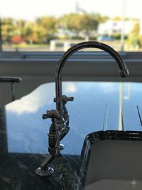 Close-up of water faucet against sky