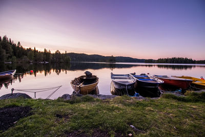 Boats moored in lake against clear sky