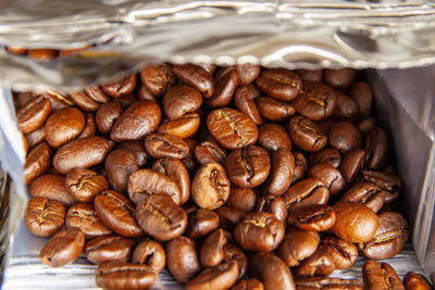 Medium-roasted coffee beans are in an open package. close-up. background image