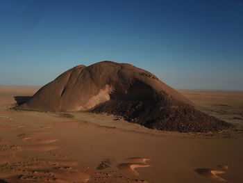 Scenic view of desert against clear blue sky