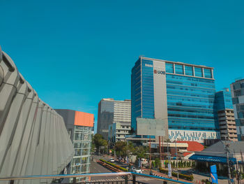 Modern buildings against clear blue sky in city