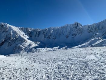 Scenic view of snowcapped mountains against clear blue sky