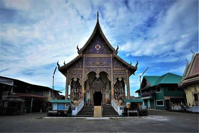 Facade of temple building against cloudy sky