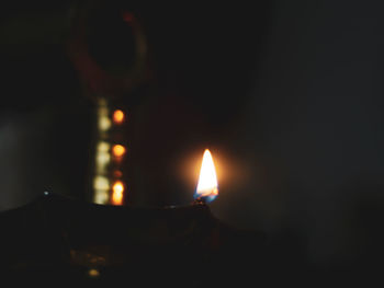 Close-up of lit candle in the dark