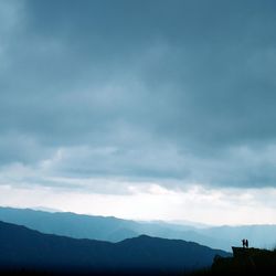 Scenic view of mountains against cloudy sky