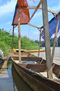 Old boat by lake against sky