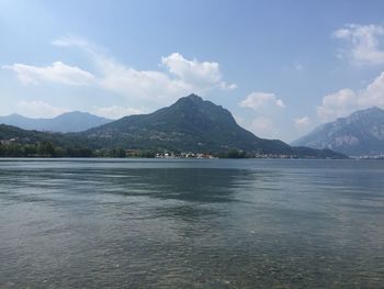 Scenic view of sea by mountains against sky