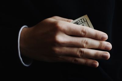 Close-up of hand over black background