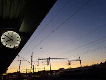Low angle view of railroad station against sky during sunset