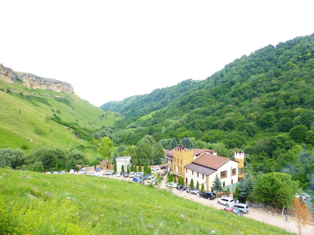 HOUSES BY MOUNTAINS AGAINST SKY