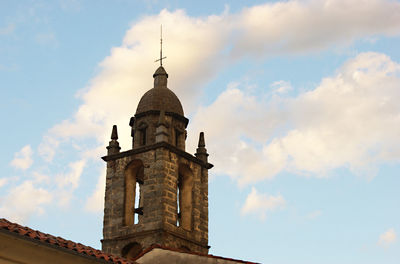 Low angle view of tower and building against sky