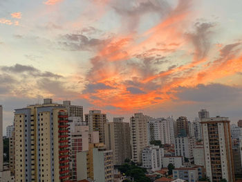 Buildings in city against sky during sunset