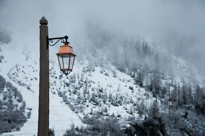 Low angle view of street light against snow covered mountain