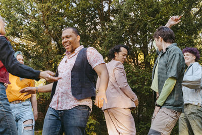 Friends of lgbtq community dancing with each other during party in back yard