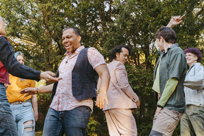 Friends of lgbtq community dancing with each other during party in back yard