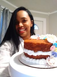 Portrait of smiling young woman cake