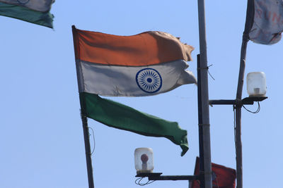 Low angle view of flag against clear blue sky