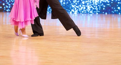 Low section of women standing on hardwood floor