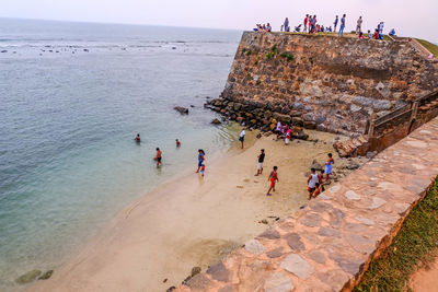 People at beach against sky