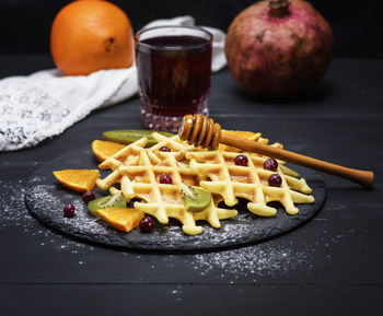 Close-up of waffle and fruits in plate on table