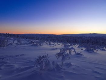 Scenic view of snow covered landscape against sky during sunset