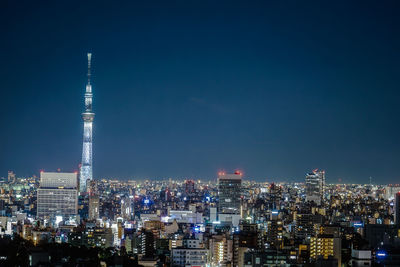 Illuminated buildings in city against sky at night