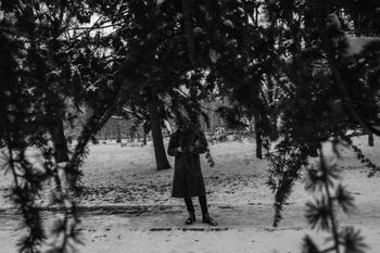 REAR VIEW OF WOMAN WALKING ON ROAD