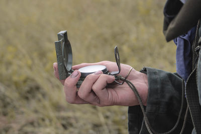 Cropped hand holding navigational compass