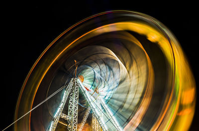 Low angle view of illuminated ferris wheel against sky at night