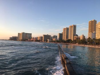 Sea by city against sky