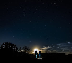 Low angle view of silhouette man standing against sky at night