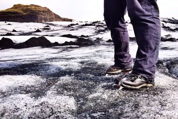 Low section of man standing on snow