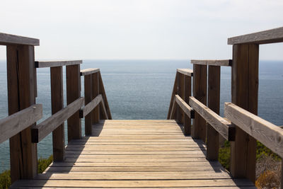 Wooden pier on sea against sky