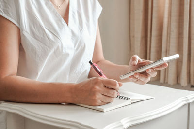 Midsection of woman using mobile phone