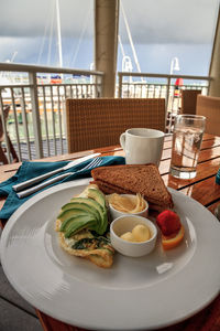 Egg white omelet with spinach, avocado slices and cheese along with wheat toast for breakfast